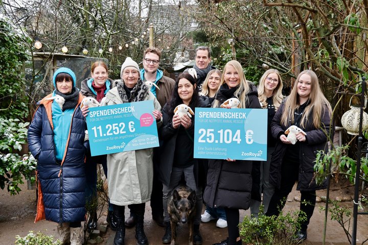 Menschen des Vereins Notpfote, des Flughafens Köln Bonn und Zooroyal halten symbolische Spendenschecks in Höhe von 11.252 Euro und 25.104 Euro.