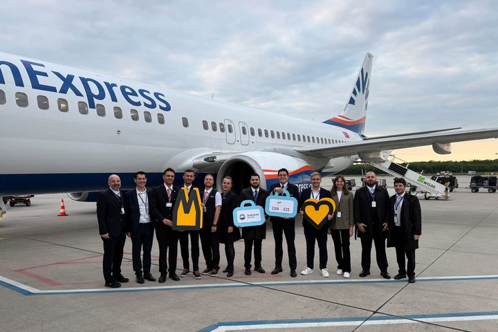 Mitarbeiter des Köln Bonn Airport Marketing und er SunExpress Crew stehen vor einem SunExpress Flugzeug